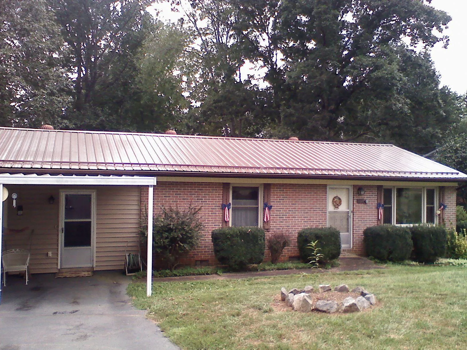 Bronze metal roof and carport on a brick ranch home — Roof Repair work by our crew in Bloomington Springs